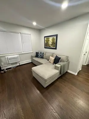 a living room with a couch and a window at Cozy 2 BR suite, 10 min to NYC &Times Sq in West New York