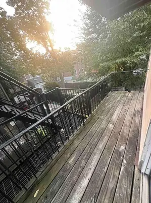 a wooden deck with a fence on a house at Cozy 2 BR suite, 10 min to NYC &Times Sq in West New York