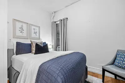 a bedroom with a bed and a chair at 2BR Apt Walk to Restaurants & Time Square in New York