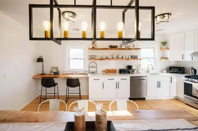 a kitchen with white cabinets and a chandelier at Very Cozy, 2 Bedroom Farmhouse Apartment 2nd FL in Lancaster