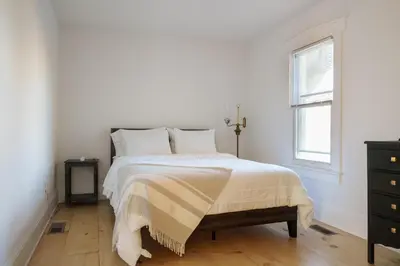 a white bedroom with a bed and a window at Very Comfy Farmhouse Apartment Unit A, 1st FL in Lancaster