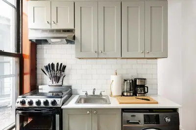a kitchen with white cabinets and a sink at 153-5A Charming 2BR LES W D in New York