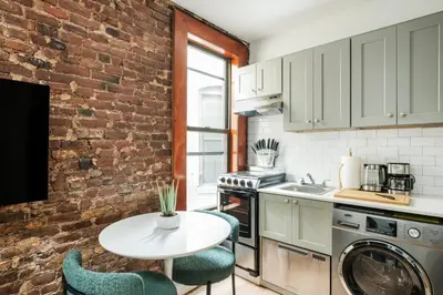 a kitchen with a table and a brick wall at 153-5A Charming 2BR LES W D in New York