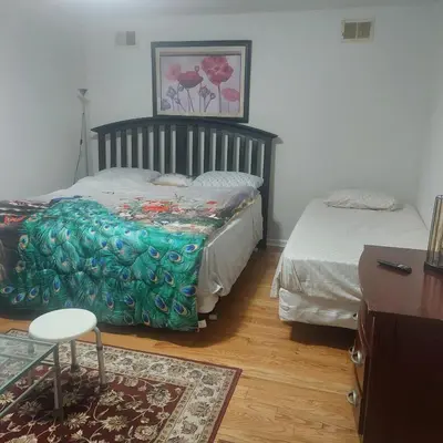 a bedroom with two beds and a table and a chair at Cosy Bedroom 12mins to Airport Prudential NJIT UMDJ Penn Station in Newark