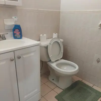 a bathroom with a toilet and a sink and toilet paper at Cosy Bedroom 12mins to Airport Prudential NJIT UMDJ Penn Station in Newark