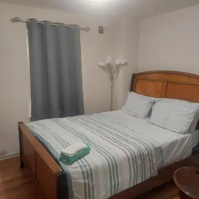 a bedroom with a bed with a wooden headboard at Cosy Bedroom 12mins to Airport Prudential NJIT UMDJ Penn Station in Newark