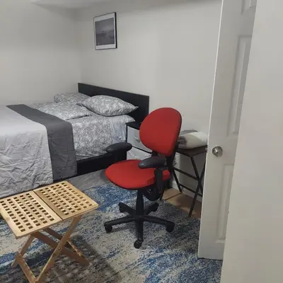 a bedroom with a red chair and a desk at Cosy Bedroom 12mins to Airport Prudential NJIT UMDJ Penn Station in Newark