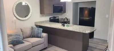 a living room with a couch and a kitchen with a counter at Lock Haven Grandview Hotel in Mill Hall