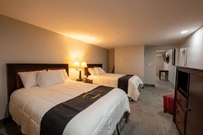 a hotel room with two beds and a television at Lock Haven Grandview Hotel in Mill Hall