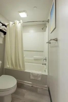 a bathroom with a white toilet and a shower at Lock Haven Grandview Hotel in Mill Hall