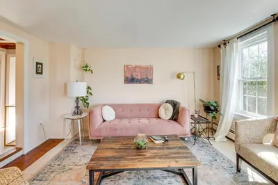a living room with a pink couch and a table at Lambertville Retreat - Walk to Shopping and Dining! in Lambertville