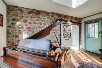 a laptop sitting on top of a piano in a room at Lambertville Retreat - Walk to Shopping and Dining! in Lambertville
