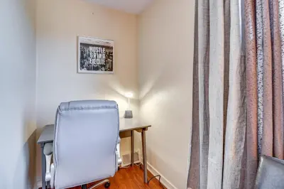 a chair and a desk in a room with a curtain at Cozy Easton Condo Near Historic Downtown in Easton