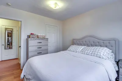 a bedroom with a white bed and a dresser at Cozy Easton Condo Near Historic Downtown in Easton