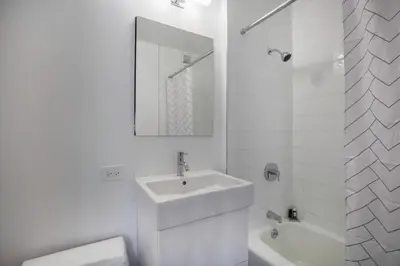 a white bathroom with a sink and a mirror at Theater District Studio w Indoor pool NYC-142 in New York