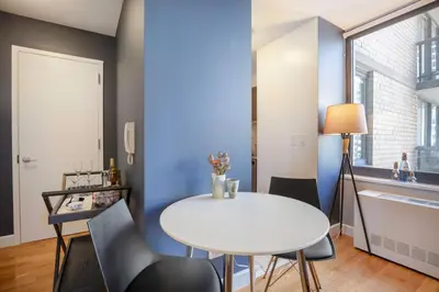 a dining room with a white table and chairs at Theater District Studio w Indoor pool NYC-142 in New York