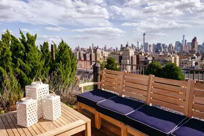 a bench on a balcony with a view of a city at UWS 2br w gym doorman elevator nr Central Park NYC-1047 in New York