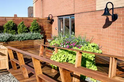 a wooden bench with flowers and plants on a patio at UWS 2br w gym doorman elevator nr Central Park NYC-1047 in New York