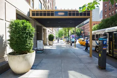 a sidewalk with a bus stop on a city street at UWS 2br w gym doorman elevator nr Central Park NYC-1047 in New York