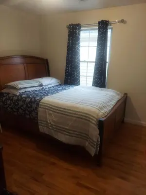 a bedroom with a large bed with a window at Crystal Room 1 Guest House near 12mins to EWR airport / Prudential / NJIT / Penn station in Newark