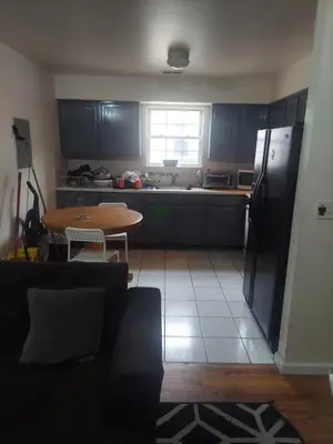 a kitchen with a table and a refrigerator and a table and chairs at Crystal Room 1 Guest House near 12mins to EWR airport / Prudential / NJIT / Penn station in Newark
