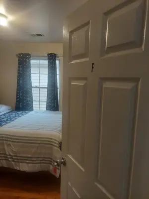 a bedroom with a bed and a door with a window at Crystal Room 1 Guest House near 12mins to EWR airport / Prudential / NJIT / Penn station in Newark