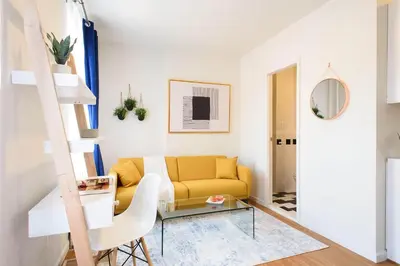a living room with a yellow couch and a glass table at Renovated 1br in East Village in New York