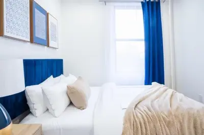 a white bed with pillows in a room with a window at 180-2 Brand new 2BR 1Bath East Village in New York