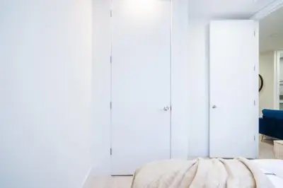 a bedroom with white walls and a bed and a mirror at 180-2 Brand new 2BR 1Bath East Village in New York