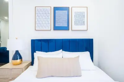 a bed with a blue headboard and a pillow on it at 180-2 Brand new 2BR 1Bath East Village in New York