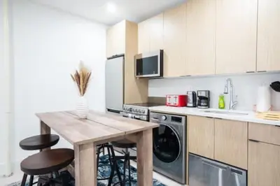a kitchen with a table and two stools at 180-2 Brand new 2BR 1Bath East Village in New York