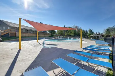 a group of blue chairs and a swimming pool at Fire Pit, Pool and Beach Access Tobyhanna Home! in Tobyhanna