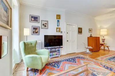 a living room with a green chair and a television at MCM-Inspired Philadelphia Apartment Private Deck in Philadelphia