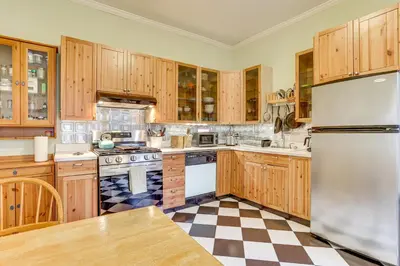 a kitchen with wooden cabinets and a checkered floor at MCM-Inspired Philadelphia Apartment Private Deck in Philadelphia