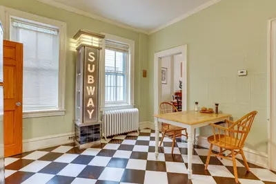a dining room with a table and chairs and a sign at MCM-Inspired Philadelphia Apartment Private Deck in Philadelphia
