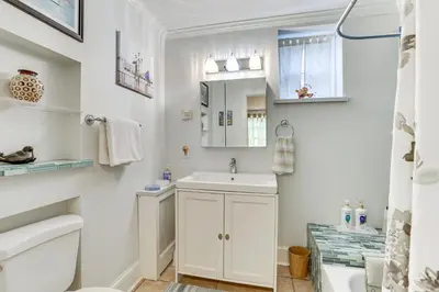 a white bathroom with a sink and a toilet at MCM-Inspired Philadelphia Apartment Private Deck in Philadelphia