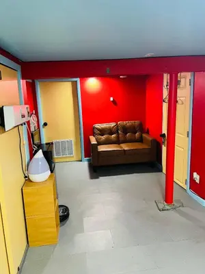 a living room with a couch and red walls at Single Room with Bathroom in Irvington