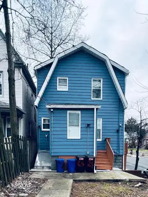 a blue house with white windows and a porch at Single Room with Bathroom in Irvington