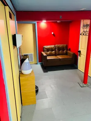a living room with a couch and a red wall at Single Room with Bathroom in Irvington