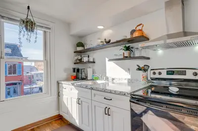 a kitchen with white cabinets and a window at Charming Pottstown Apartment - Walk to Town! in Pottstown