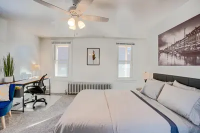 a bedroom with a bed and a desk and a ceiling fan at Charming Pottstown Apartment - Walk to Town! in Pottstown