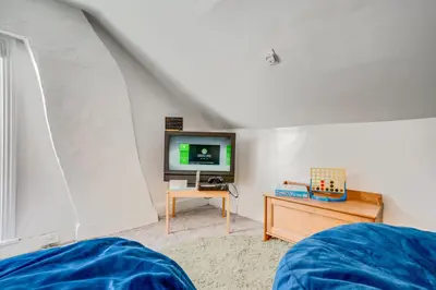 a bedroom with a tv and a table with a bed at Charming Pottstown Apartment - Walk to Town! in Pottstown
