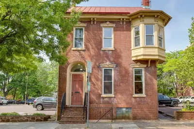 an old red brick house with a red door at Charming Pottstown Apartment - Walk to Town! in Pottstown