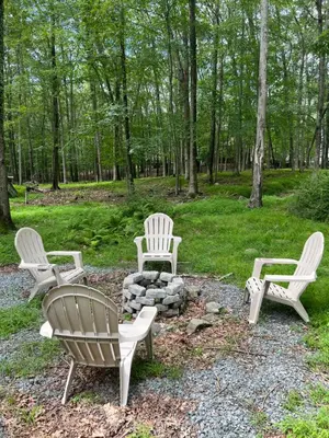 three chairs and a fire pit in a yard at The Flying Dutchman Cottage in amenities filled Masthope community Ski Big Bear in Lackawaxen