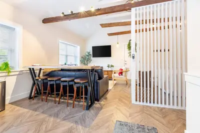 a kitchen and living room with a bar with stools at AmishGuestCottage~cozystudio~hottub~patio in Gordonville