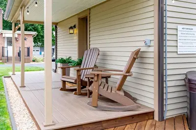 a porch with two chairs and a wooden table at AmishGuestCottage~cozystudio~hottub~patio in Gordonville