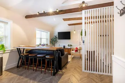 a kitchen with a table and bar with stools at AmishGuestCottage~cozystudio~hottub~patio in Gordonville