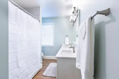 a white bathroom with a sink and a shower at The Queen Place - Updated-Private Backyard in Gordonville