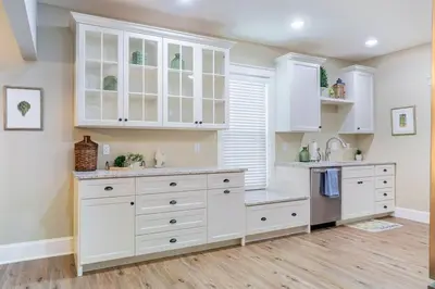 a kitchen with white cabinets and a wooden floor at The Queen Place - Updated-Private Backyard in Gordonville