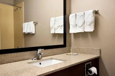 a bathroom with a sink and a mirror and towels at Super 8 by Wyndham Hershey Chocolate Avenue in Hershey